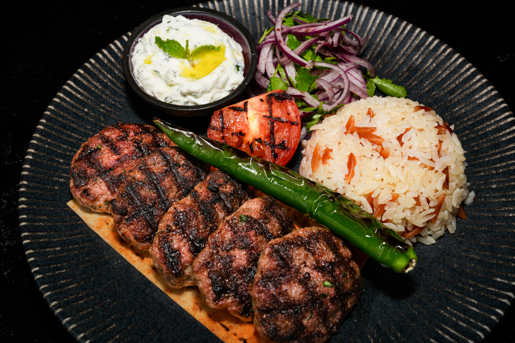 Grilled meat patties with rice and yogurt, viewed from above