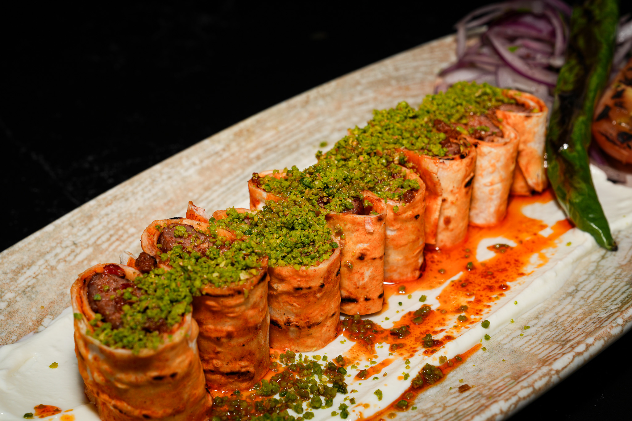 Close-up of pistachio-topped kebab rolls