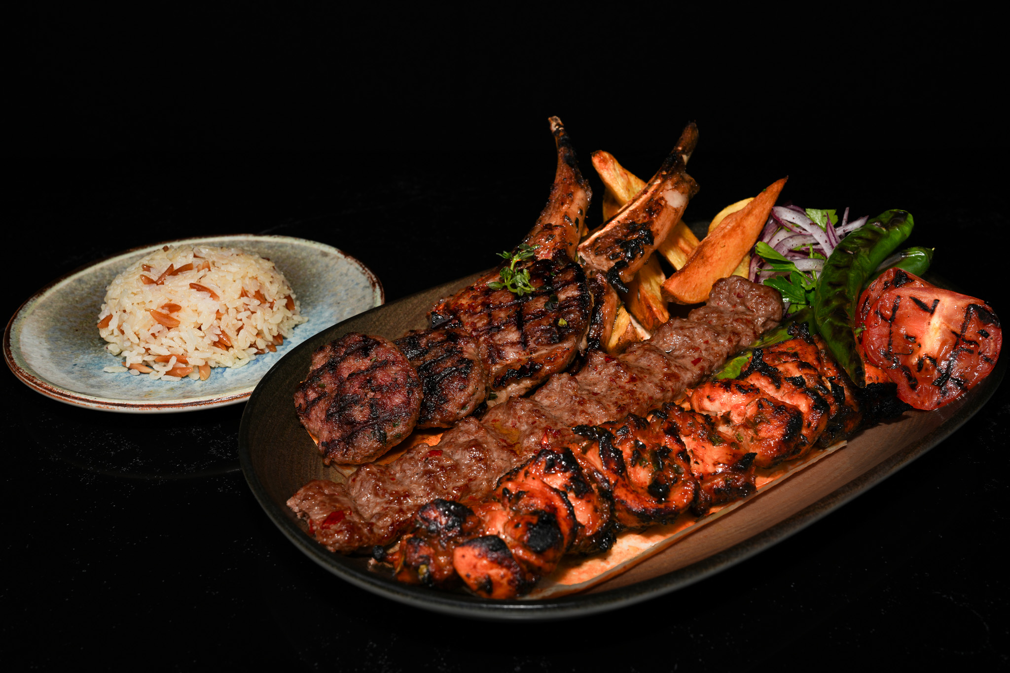 Mixed grill of lamb chops, chicken, and kebabs with rice
